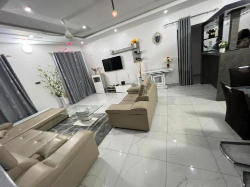 a large living room with couches and a tv at TGS home in Lomé