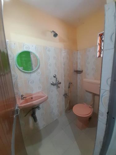 a bathroom with a pink toilet and a sink at Cassa ff guesthouse in Palolem