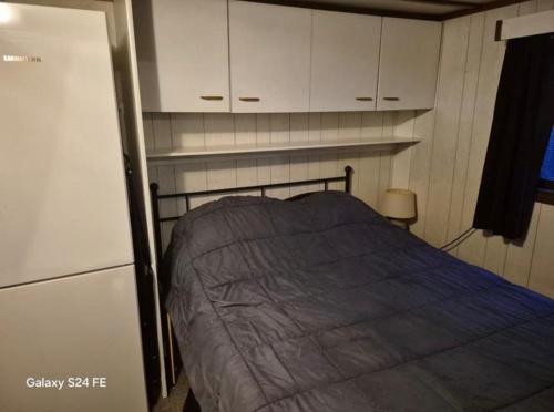 a small bedroom with a bed and white cabinets at Chalet te huur op Camping de Kleine Wielen te Leeuwarden in Leeuwarden