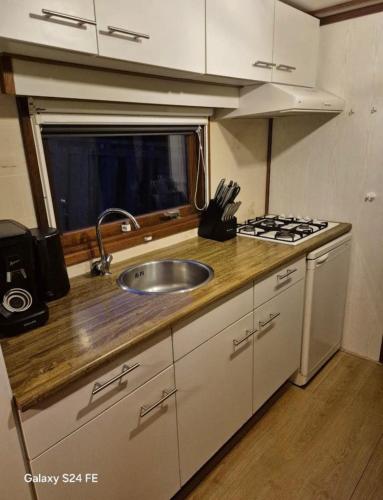 a kitchen with a sink and a stove at Chalet te huur op Camping de Kleine Wielen te Leeuwarden in Leeuwarden