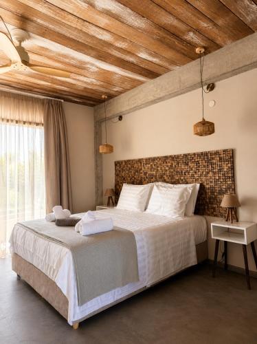 a bedroom with a large bed with a brick wall at Pefkon Suites in Afitos