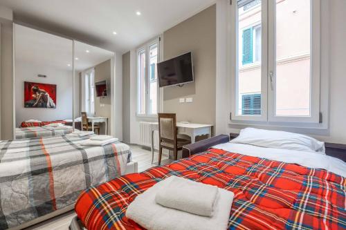 a bedroom with two beds and a tv and a table at De'Giudei, Bologna by Short Holidays in Bologna