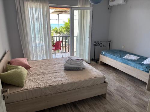 a bedroom with two beds and a balcony at Kety House in Makhinjauri