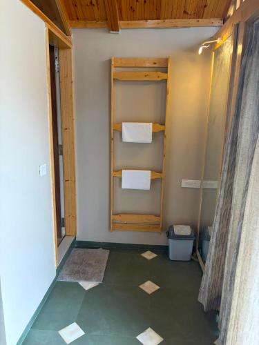 a bathroom with a green floor and a wall with towels at Dream Habitat in Wādhiware