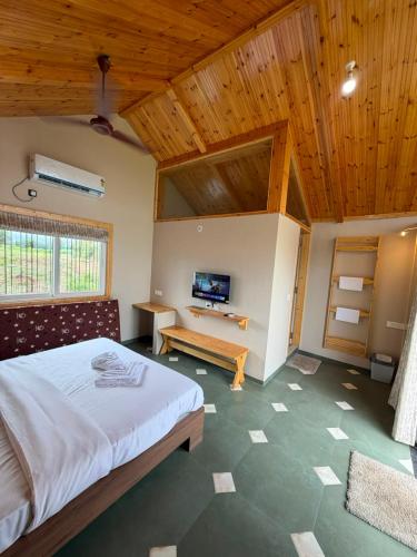 a bedroom with a large bed and a wooden ceiling at Dream Habitat in Wādhiware