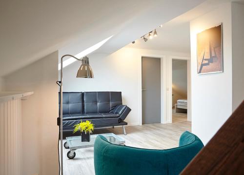 - un salon avec un canapé et un fauteuil bleu dans l'établissement Ferienwohnung Schwarz, à Mayen