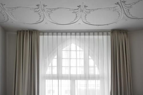 a room with a window with curtains and a ceiling at Roomers Berlin Steinplatz, Autograph Collection in Berlin