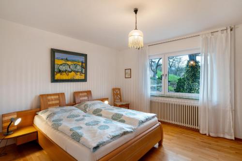 a bedroom with a bed and a large window at Haus Am Schroffen in Ottenhöfen
