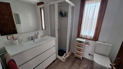 a bathroom with a sink and a toilet and a mirror at Chalet del Daniel en La Calabaza in Aranda de Duero