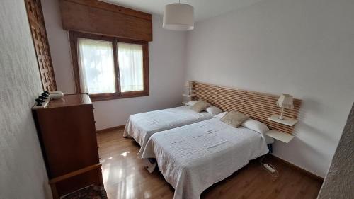 a bedroom with two beds and a window at Chalet del Daniel en La Calabaza in Aranda de Duero