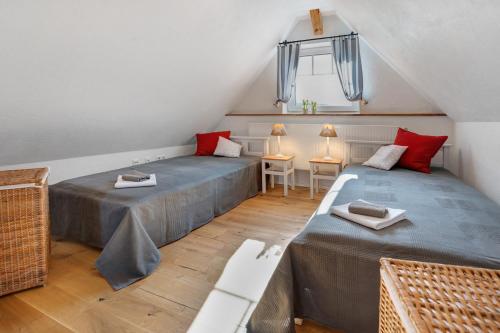 two beds in a attic room with red pillows at Villa Pauline in Baiersbronn