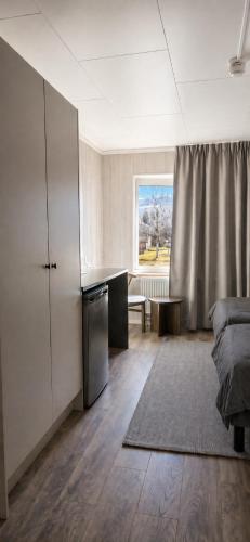 a bedroom with a bed and a desk and a window at Vemdalen Base Camp in Vemdalen