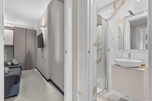 a white bathroom with a sink and a mirror at SeaFrontBonassola in Bonassola