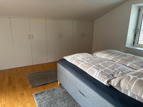 a bedroom with two beds and white cabinets and a window at Bergzauber in Bludenz