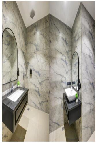 a bathroom with two sinks and two mirrors at Hotel Heritage Suites in New Delhi