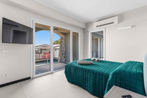 a bedroom with a green bed and a balcony at SeaFrontBonassola in Bonassola