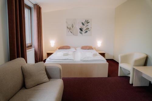 a hotel room with a bed and a couch at Penzion Maděřič in Moravský Žižkov