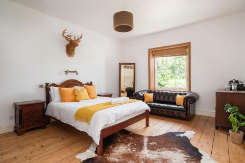 a bedroom with a large bed and a couch at Finest Retreats - Walltree House in Brackley
