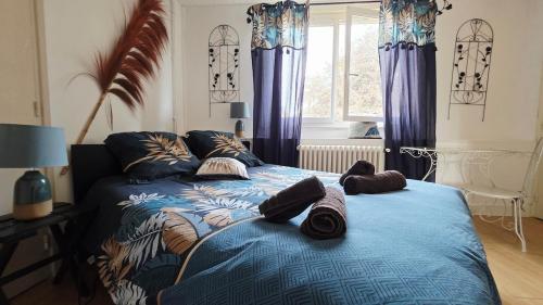 a bedroom with a blue bed with pillows on it at Domaine Les Tourelles - Gîte 4 in Caffiers