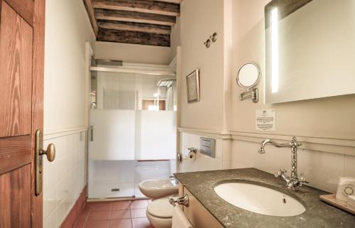 a bathroom with a sink and a toilet at Hotel San Antonio el Real in Segovia