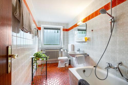 a bathroom with a tub and a toilet and a sink at fewo-loh4-sinsheim in Sinsheim