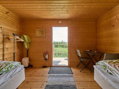 a wooden room with two beds and a door at Itärajan Helmi in Tohmajärvi