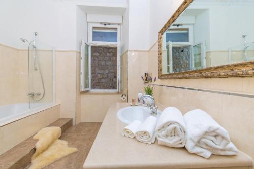 a bathroom with a sink and a shower and a mirror at Luxury Seafront Apartment Banje in Dubrovnik