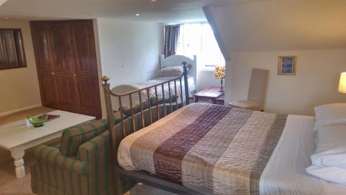 a bedroom with a bed and a desk in a room at The Globe Inn in Chagford