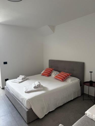 a white bed with red pillows and towels on it at Villa Lavinia a Colico in Colico