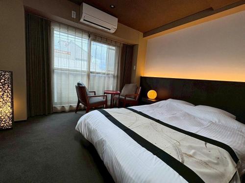 a hotel room with a bed and a table and chairs at ITOSHI Kyoto Stay 京都天神401 in Kyoto