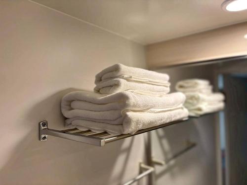 a pile of towels on a towel rack in a bathroom at ITOSHI Kyoto Stay 京都天神401 in Kyoto