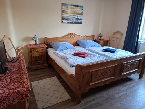 a bedroom with a large wooden bed with blue pillows at Ferienwohnung Schneifelsicht in Auw