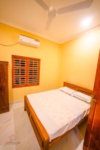 a bedroom with a bed and a air conditioner at Zen Nallur in Jaffna