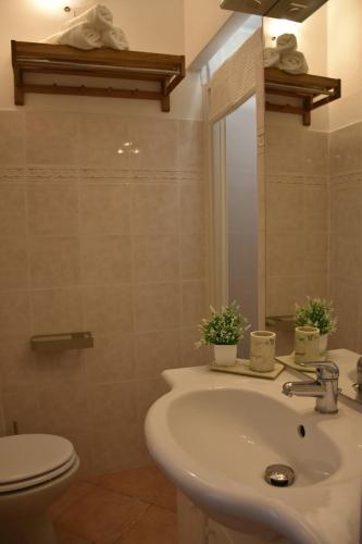 a bathroom with a sink and a toilet and a mirror at Sunny Apartment in La Spezia