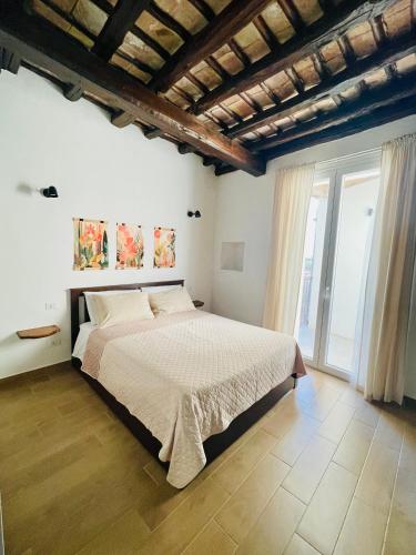 a bedroom with a bed and a large window at Loft Al Baglio del Gelso in Balestrate