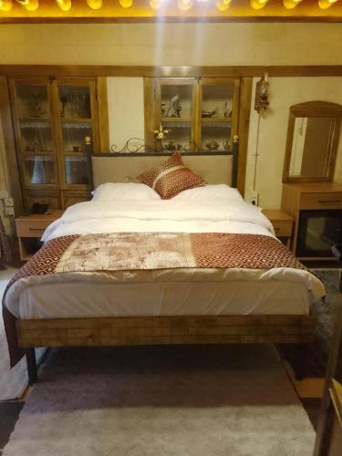 a bedroom with a large bed with a wooden headboard at Hurşit Bey Konağı in Gaziantep