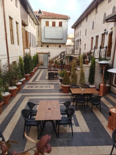 a courtyard with tables and chairs and potted plants at Hurşit Bey Konağı in Gaziantep