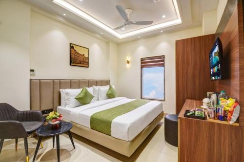 a hotel room with a bed and a tv at Hotel Heritage Suites in New Delhi