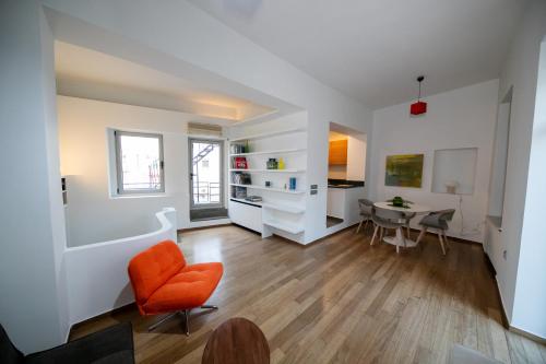 a living room with an orange chair and a table at Acropolis Neoclassic Elegance in Athens