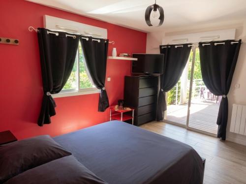 a bedroom with red walls and a bed and a tv at La Villa des Demoiselles in Bourg-Achard