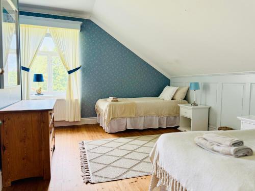 a attic bedroom with two beds and a window at Udden Retreat-Bed & Breakfast in Skinnskatteberg