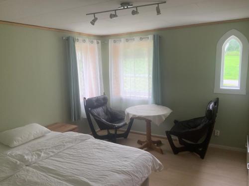 a bedroom with a bed and a table and chairs at Ørntua in Rekdal
