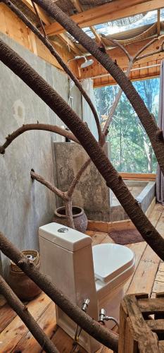 a bathroom with a toilet in a room with wooden floors at Hidden Cabin in Iringa