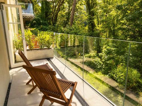 a balcony with a chair and a view of a garden at Watersmeet Terrace in Lynmouth