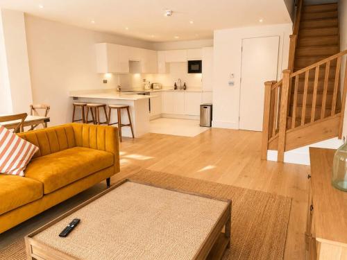 a living room with a couch and a kitchen at Watersmeet Terrace in Lynmouth