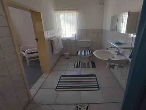 a white bathroom with a sink and a toilet at BKZ Self-Catering in Solitaire