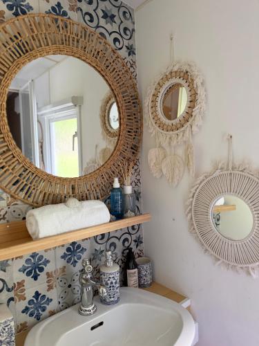 a bathroom with two mirrors and a sink at Domek holenderski Hampton in Dominice