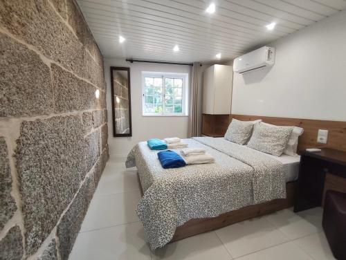 a bedroom with two beds and a stone wall at Quinta Cunha in São Pedro do Sul