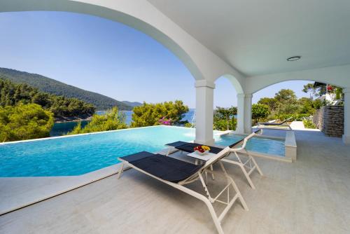 a patio with a table and chairs next to a swimming pool at Villa Christy in Čara