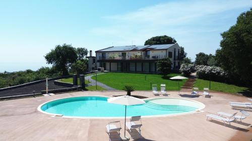 a house with a swimming pool in front of a house at Paolimura Resort , Apartment & Spa in Aci Catena